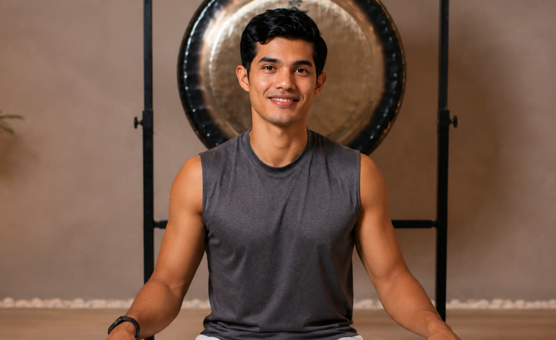 Yang, certified yoga and breathwork instructor, smiling in front of a gong